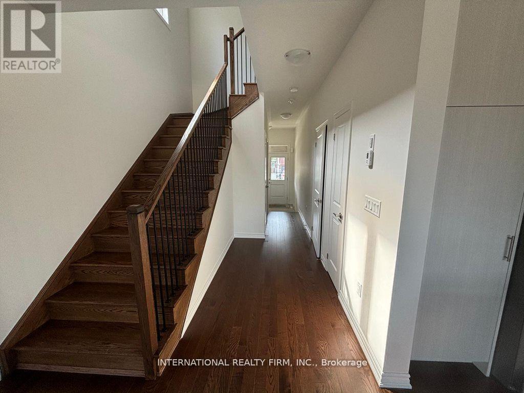 A hallway with a staircase and doors on the right side.