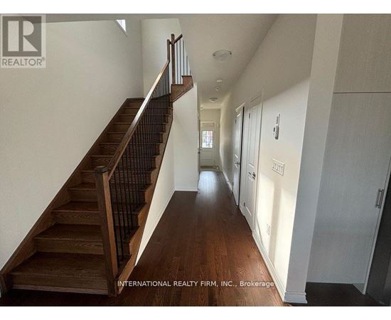 A hallway with a staircase and doors on the right side.