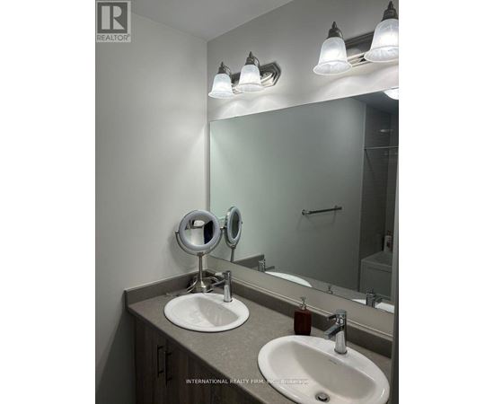 A bathroom with a sink, mirror, and lights.