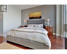 A bedroom with a large bed and a painting above it.