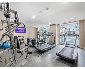 A well-equipped home gym with a television and a view of the city.