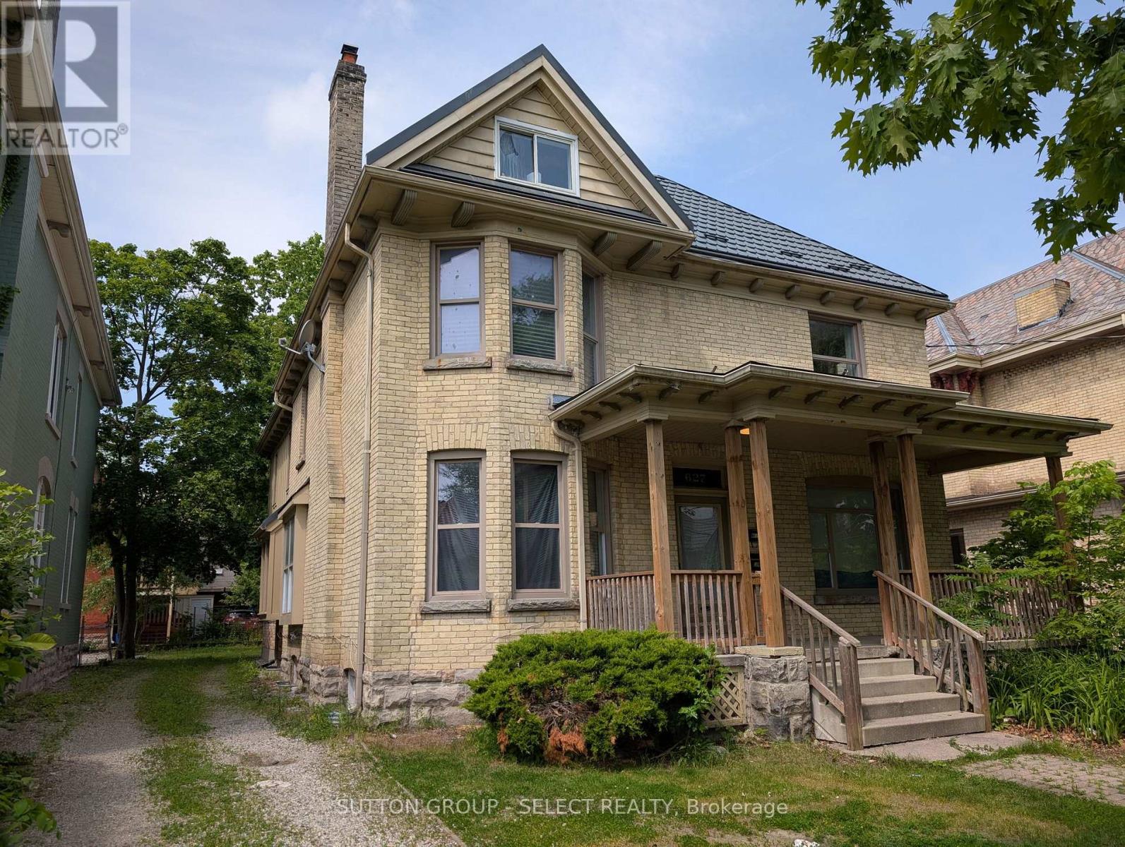 A house with a porch and a stone wall in front.