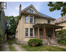 A house with a porch and a stone wall in front.