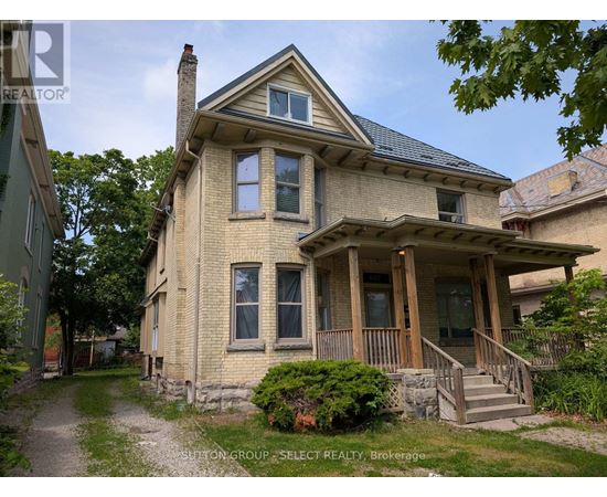 A house with a porch and a stone wall in front.