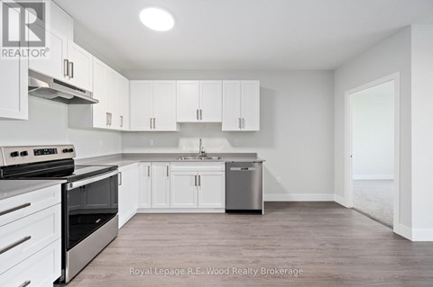 A white kitchen with a stove, oven, and cabinets.
