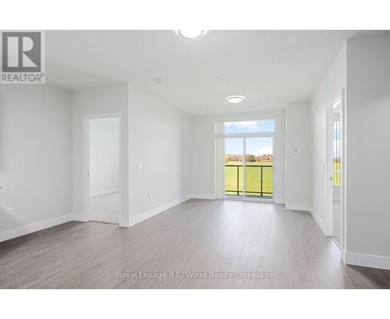A spacious room with a view of a fenced area outside through a glass door.
