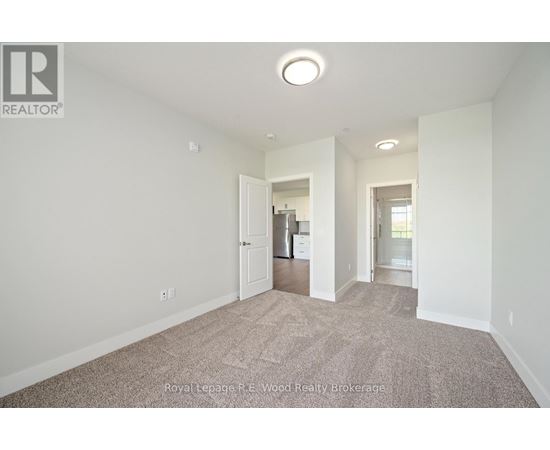 A large, empty room with a carpeted floor and white walls.