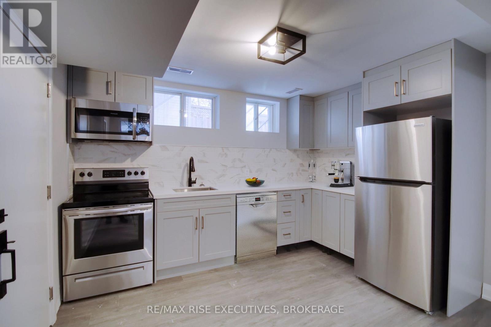 A modern kitchen with stainless steel appliances and white cabinets.