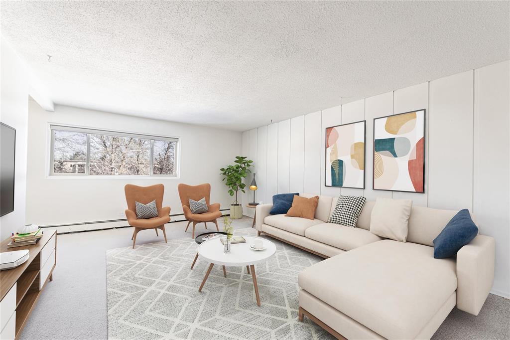 A living room with a white couch, two chairs, and a coffee table.