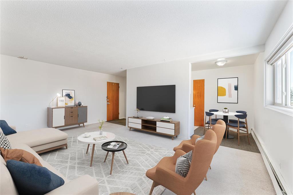 A living room with a sofa, chairs, and a television.