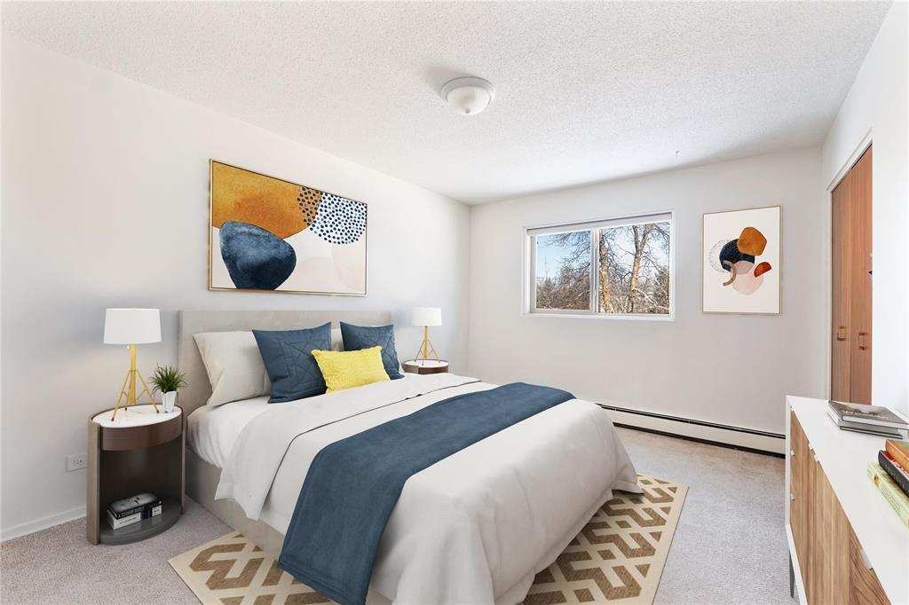 A bedroom with a bed, nightstand, and two framed pictures on the wall.