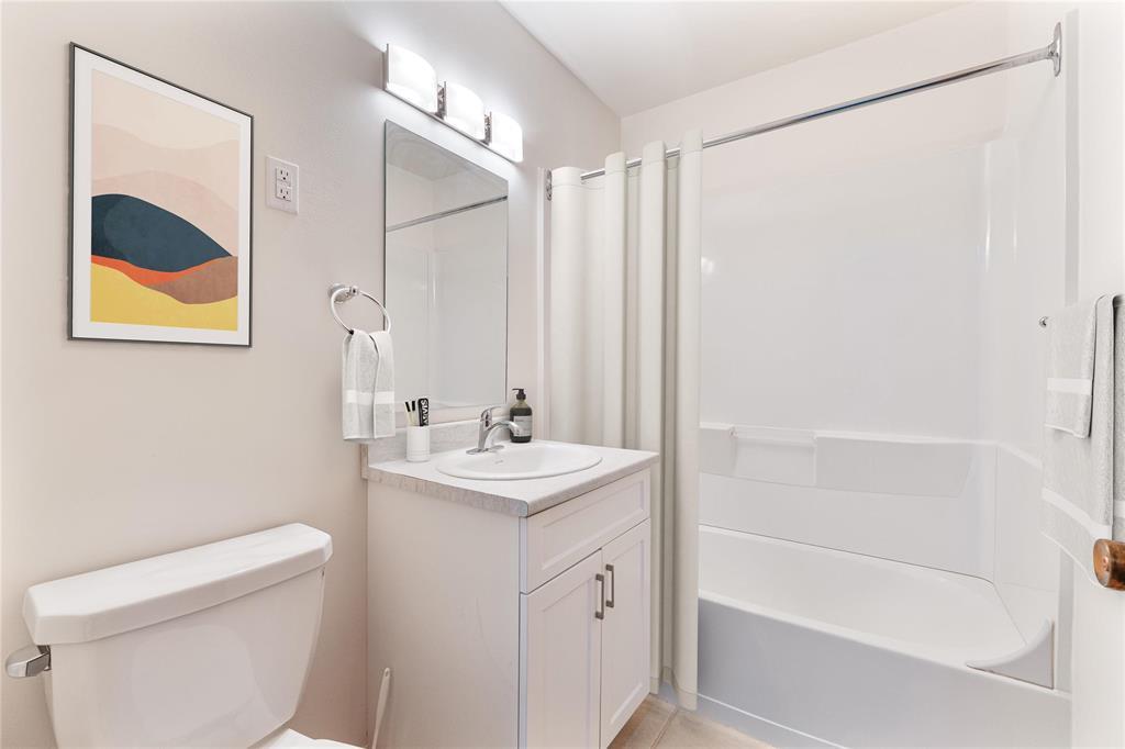 A white bathroom with a white tub and sink.
