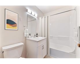 A white bathroom with a white tub and sink.