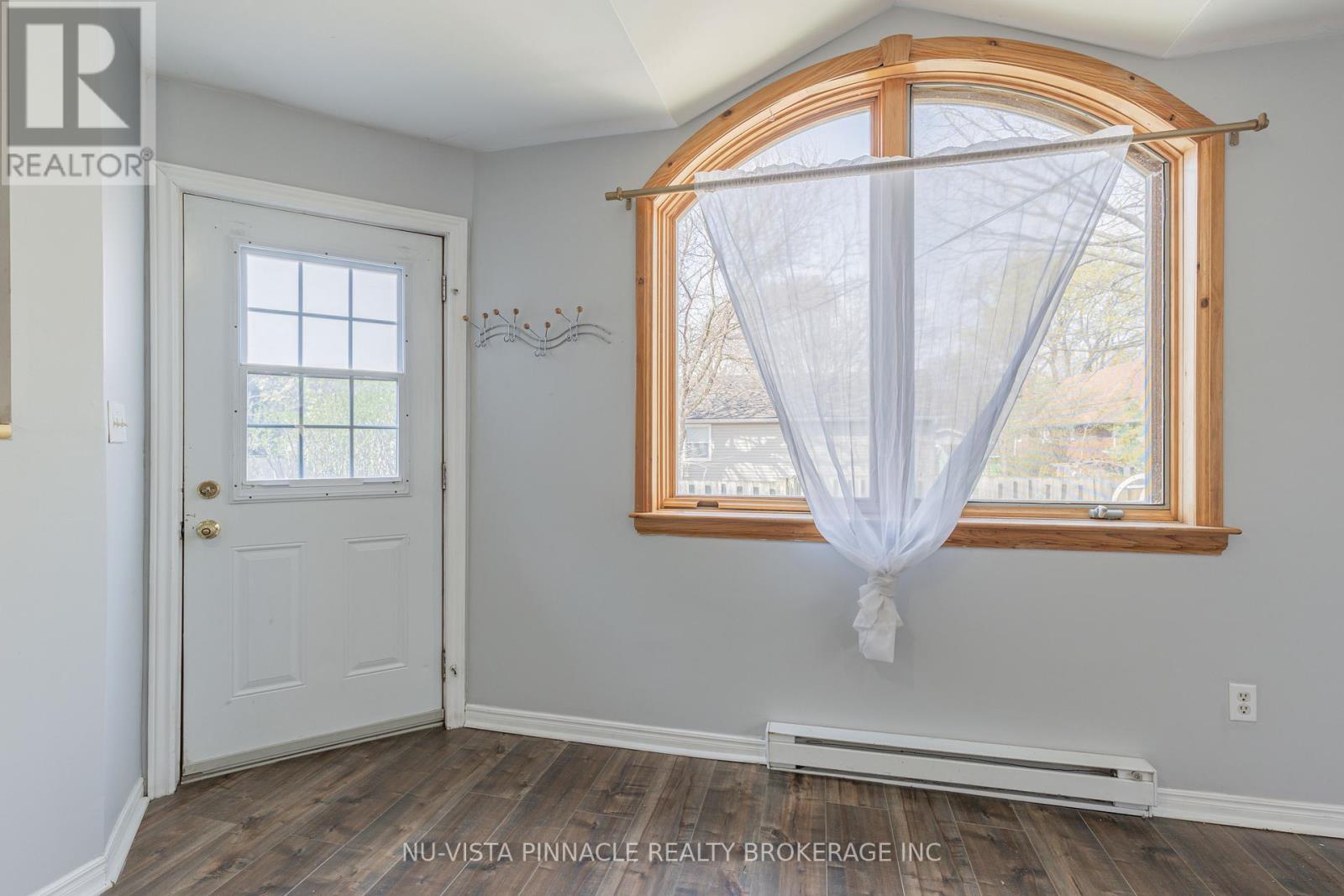 A room with a white door and a window with a white curtain.