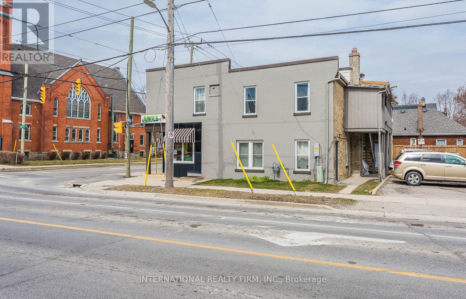 A street view with a building on the left and a car parked on the right.