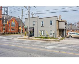 A street view with a building on the left and a car parked on the right.