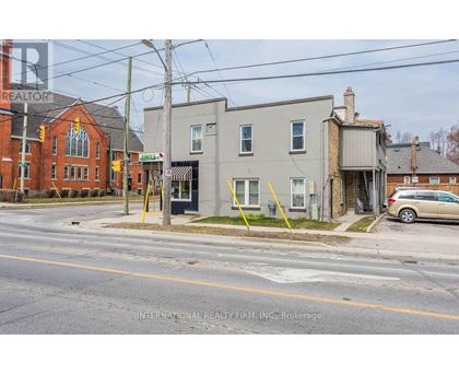 A street view with a building on the left and a car parked on the right.