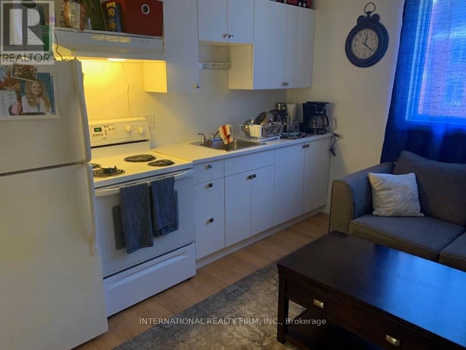 A kitchen with white cabinets and a refrigerator.
