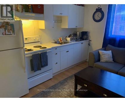 A kitchen with white cabinets and a refrigerator.