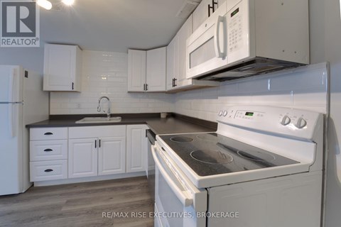 A white kitchen with a stove and a microwave.