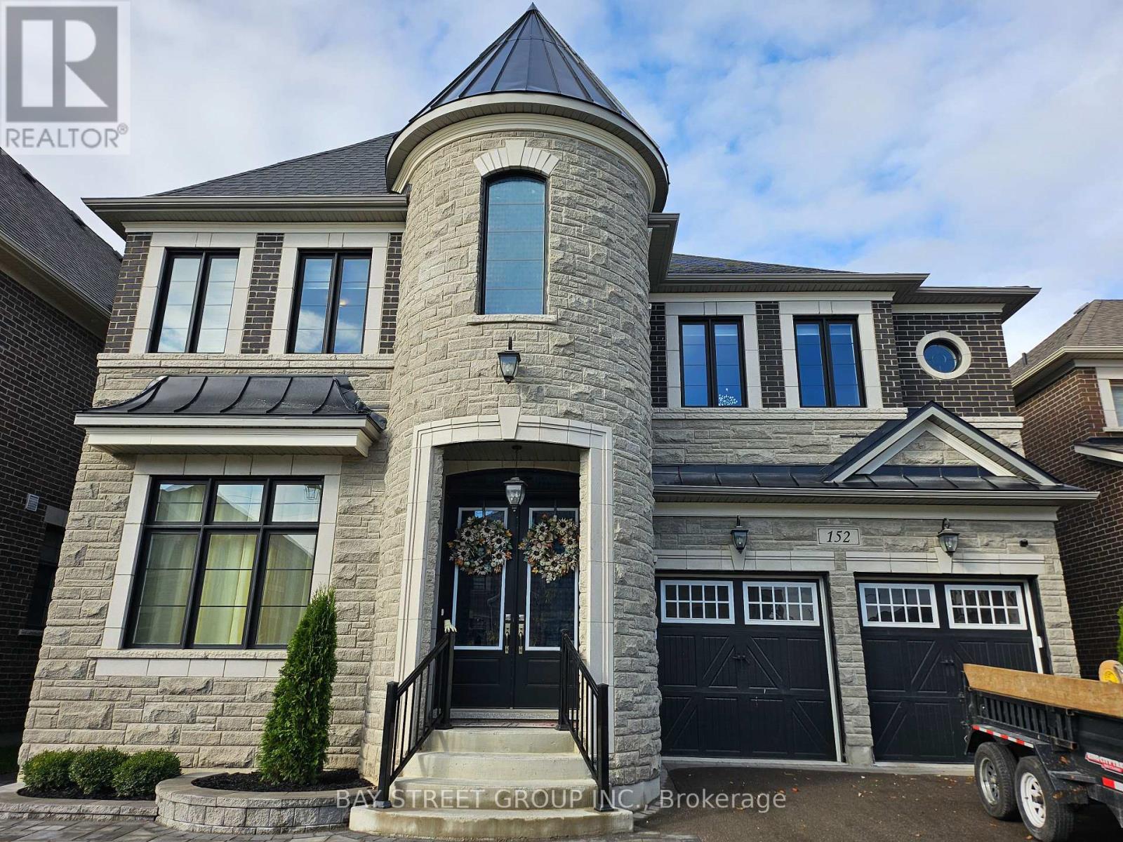 A large house with a stone facade and a black door.
