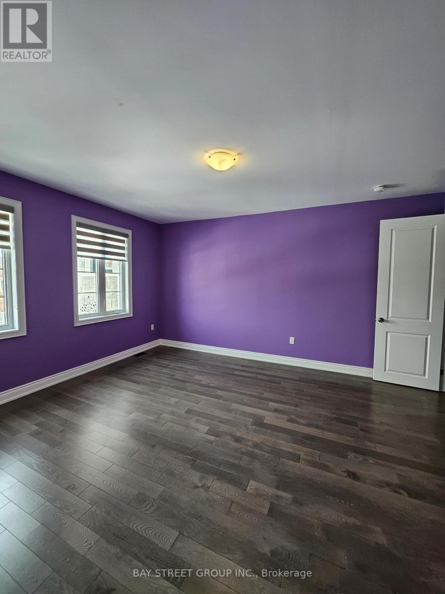 A room with purple walls and a wooden floor.