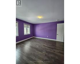 A room with purple walls and a wooden floor.