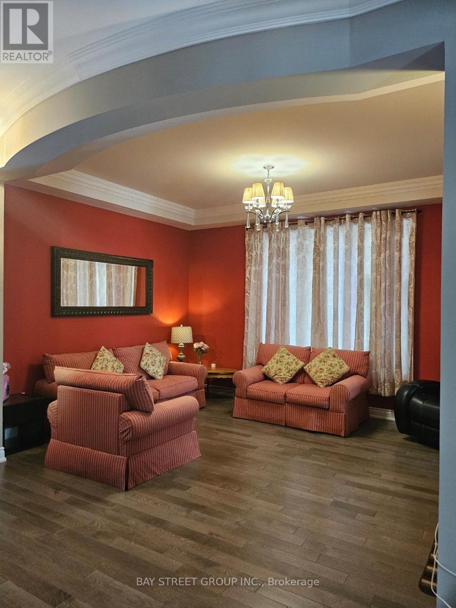 A living room with red walls and a chandelier.