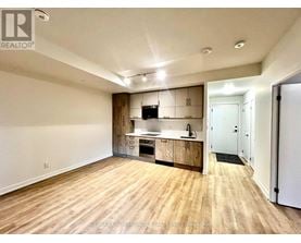 A spacious kitchen with wooden floors and white walls.