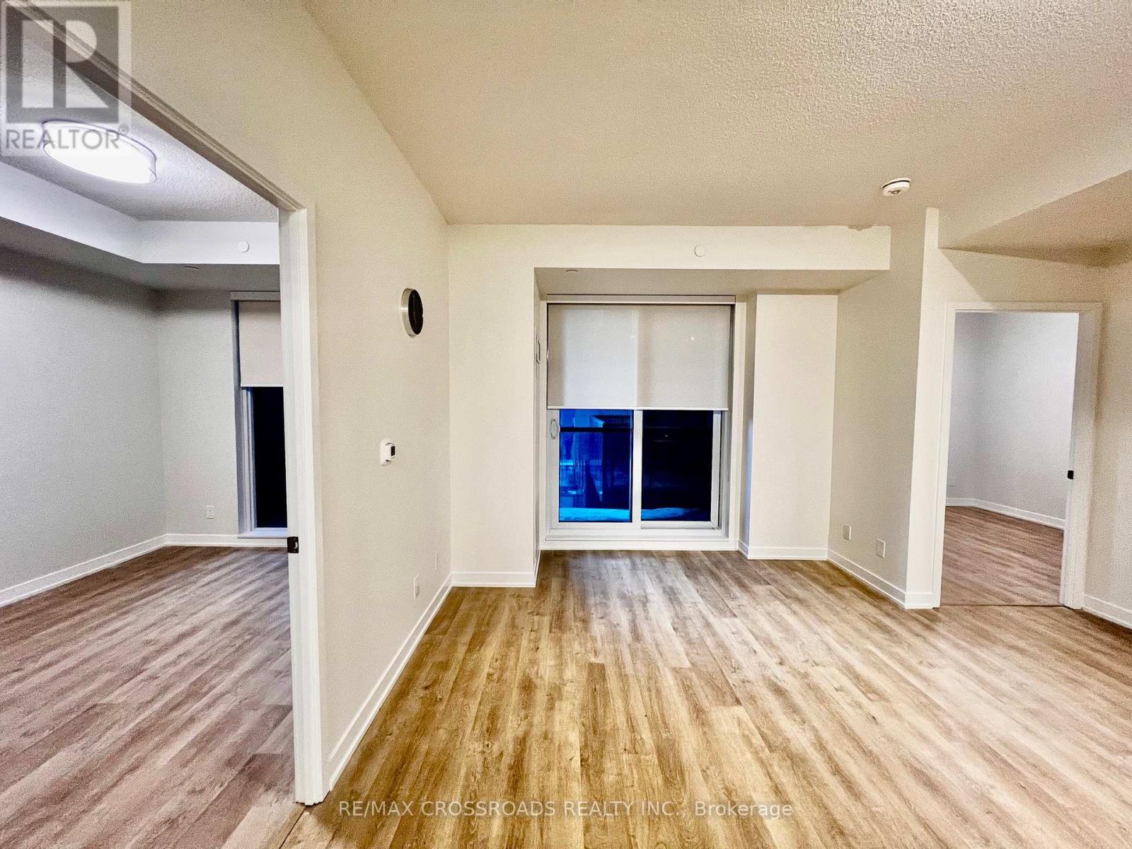 A room with wooden flooring and a sliding glass door.