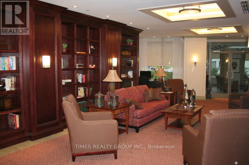 A living room with a sofa, armchair, and bookshelf.