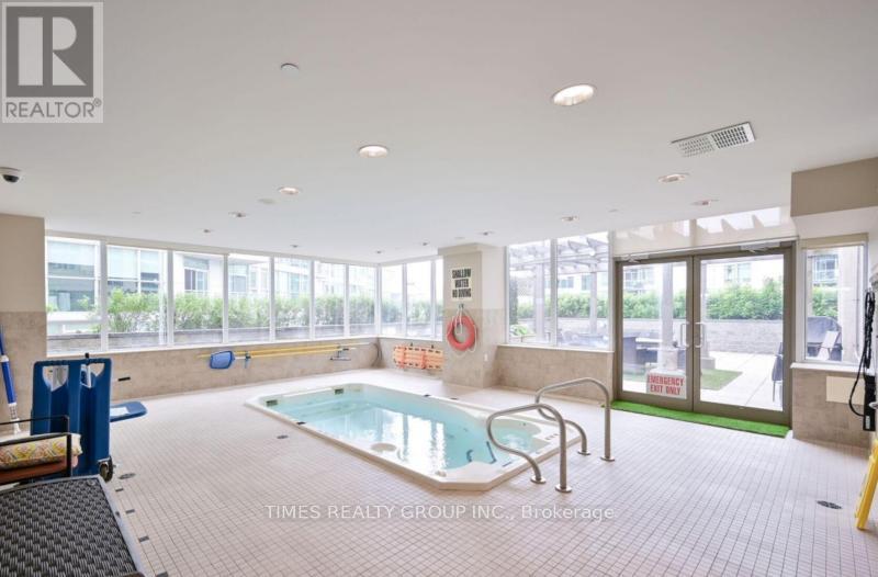 A swimming pool inside a building with a glass wall.