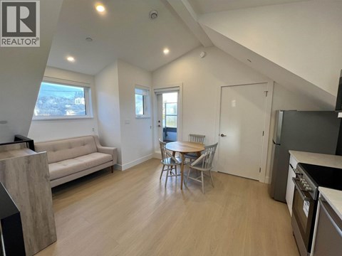 A well-lit, spacious living area with a dining table and chairs.
