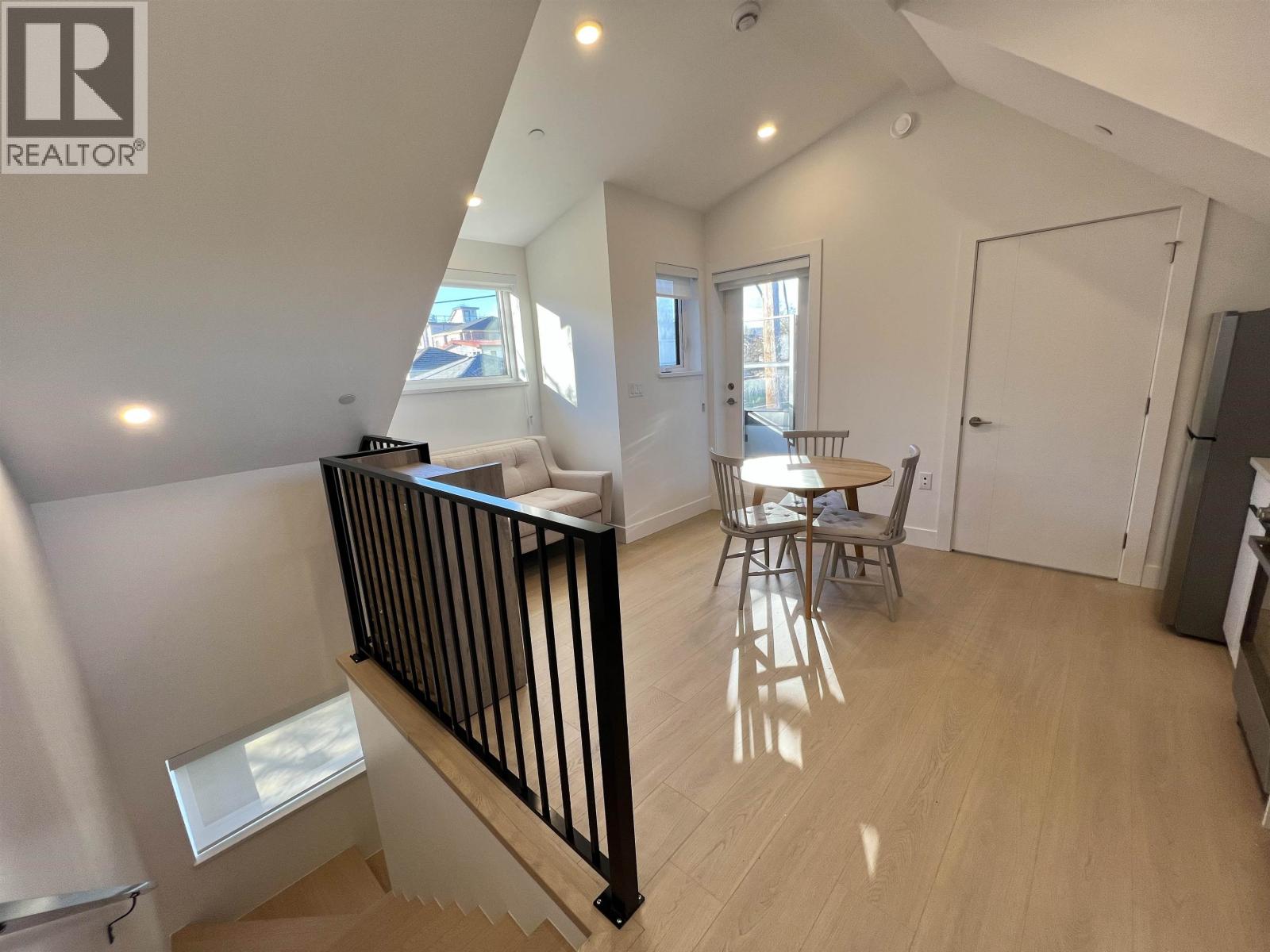 A well-lit, spacious room with a dining table and chairs.