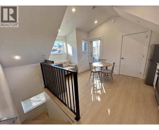 A well-lit, spacious room with a dining table and chairs.