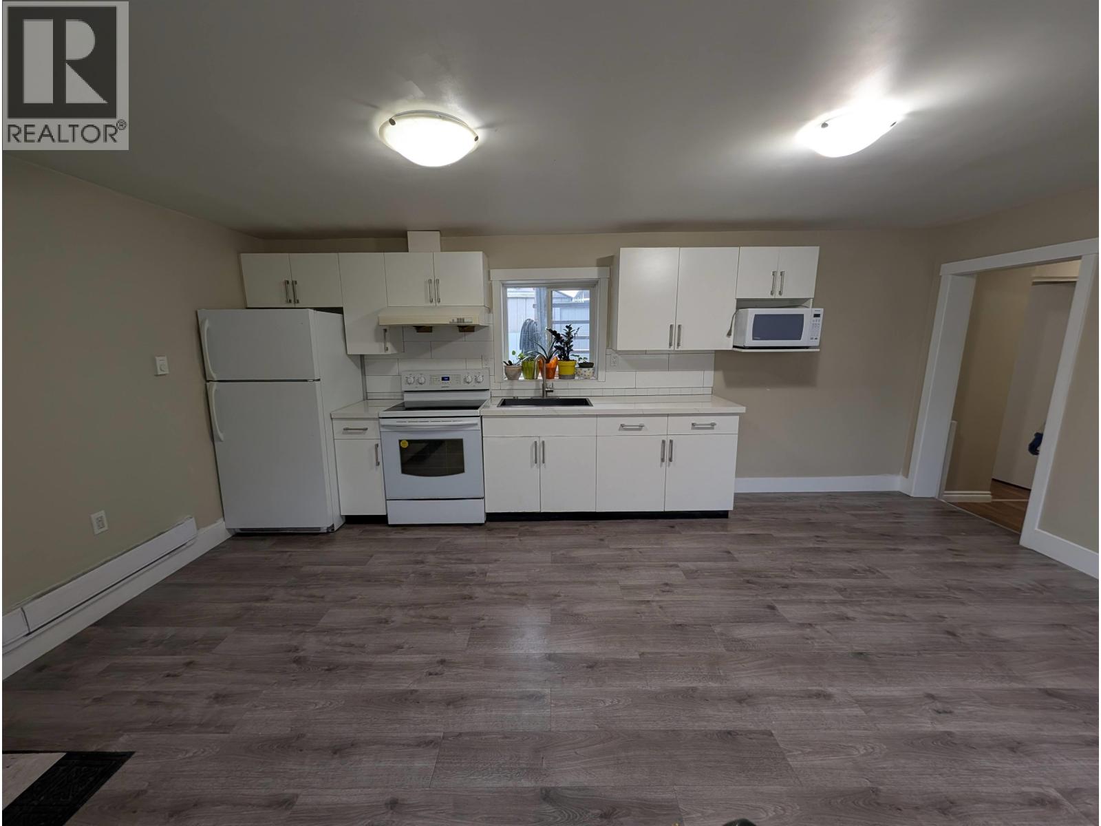 A kitchen with white appliances and cabinets.