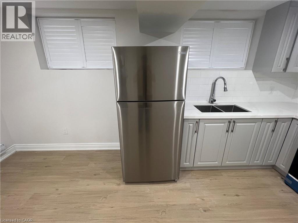 A stainless steel refrigerator in a kitchen with white cabinets.