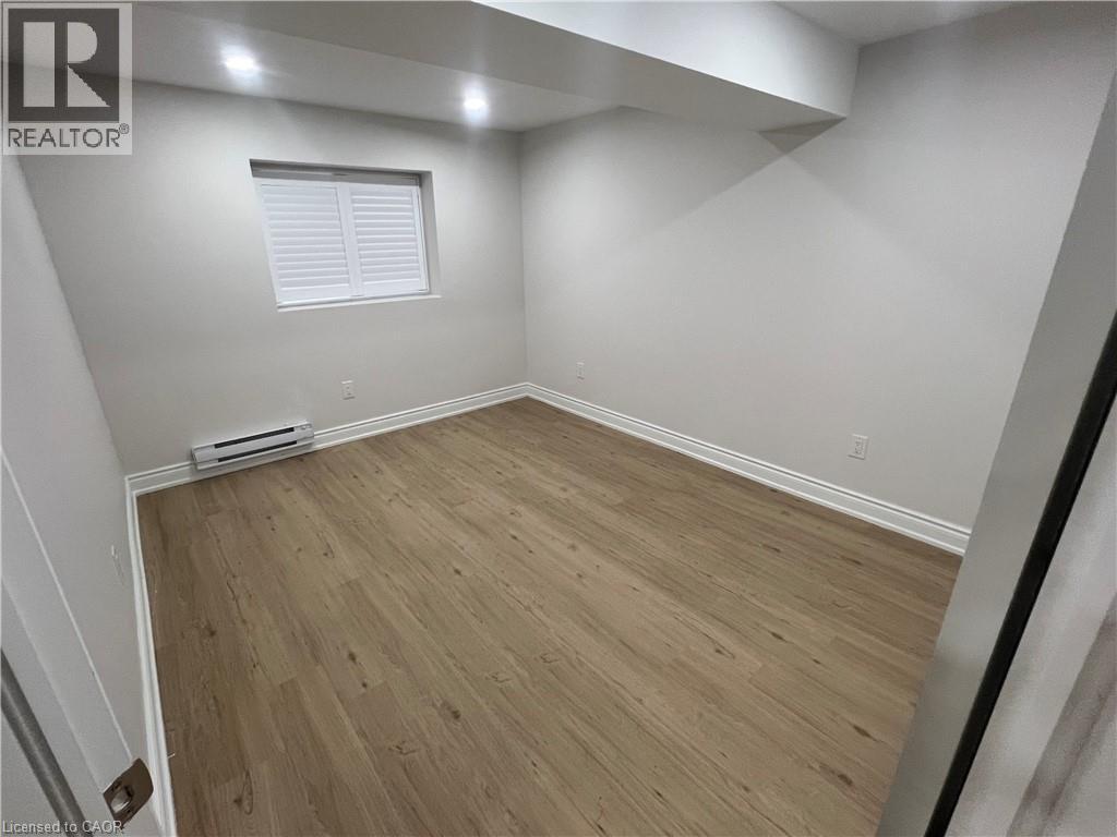 A room with wooden flooring and a window with blinds.