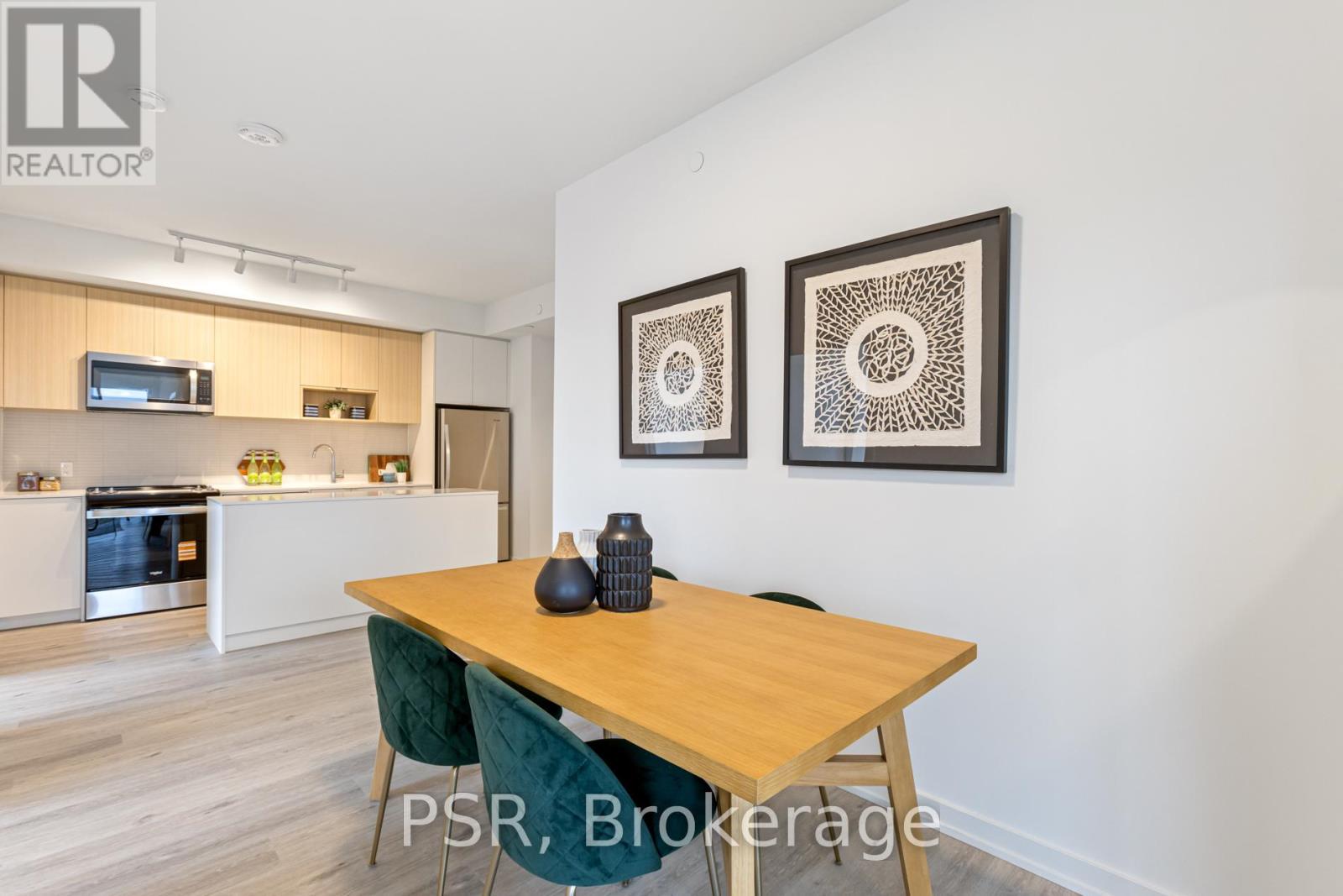 A dining room with a wooden table and chairs, and two framed artworks on the wall.