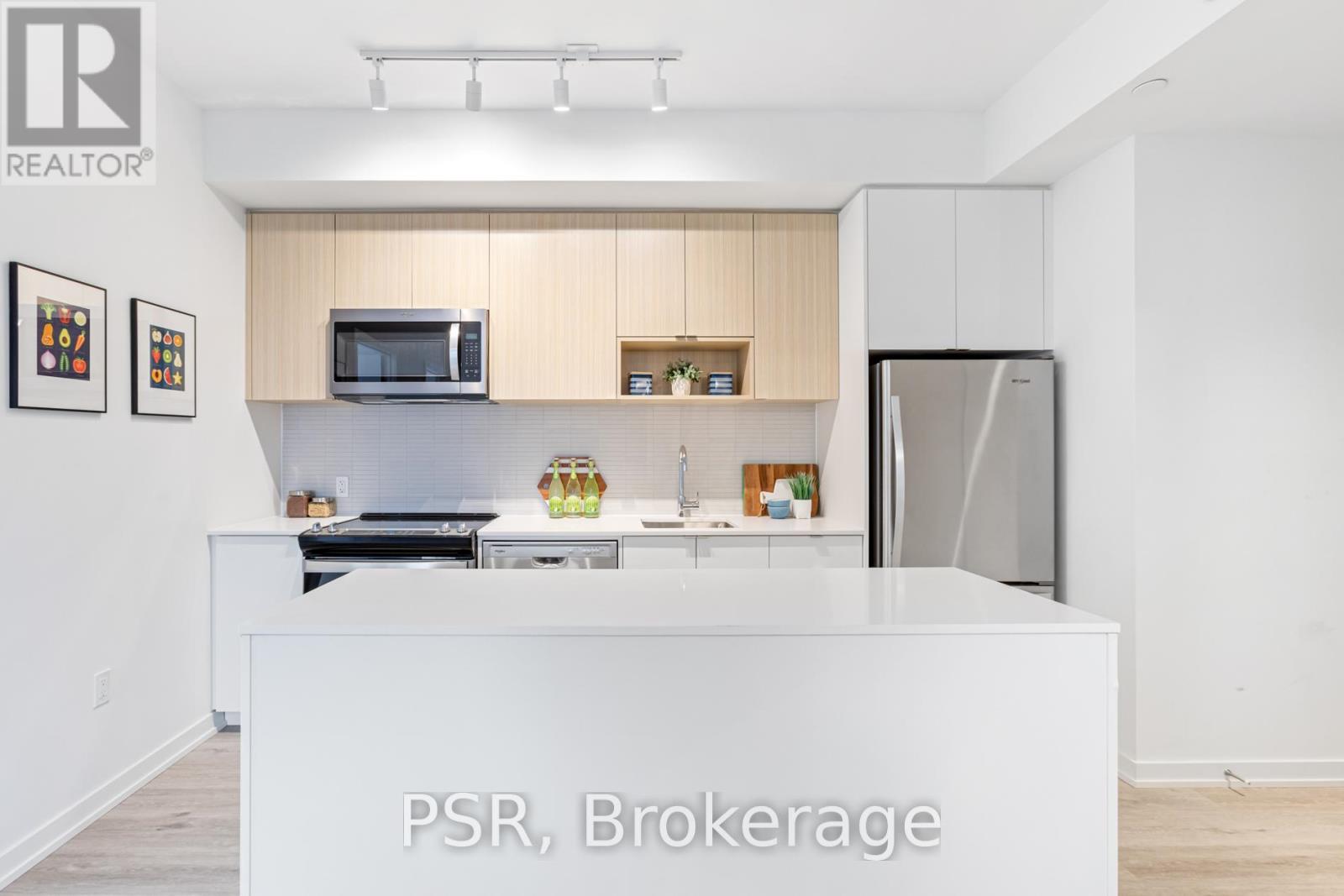 A kitchen with a white counter and a refrigerator.