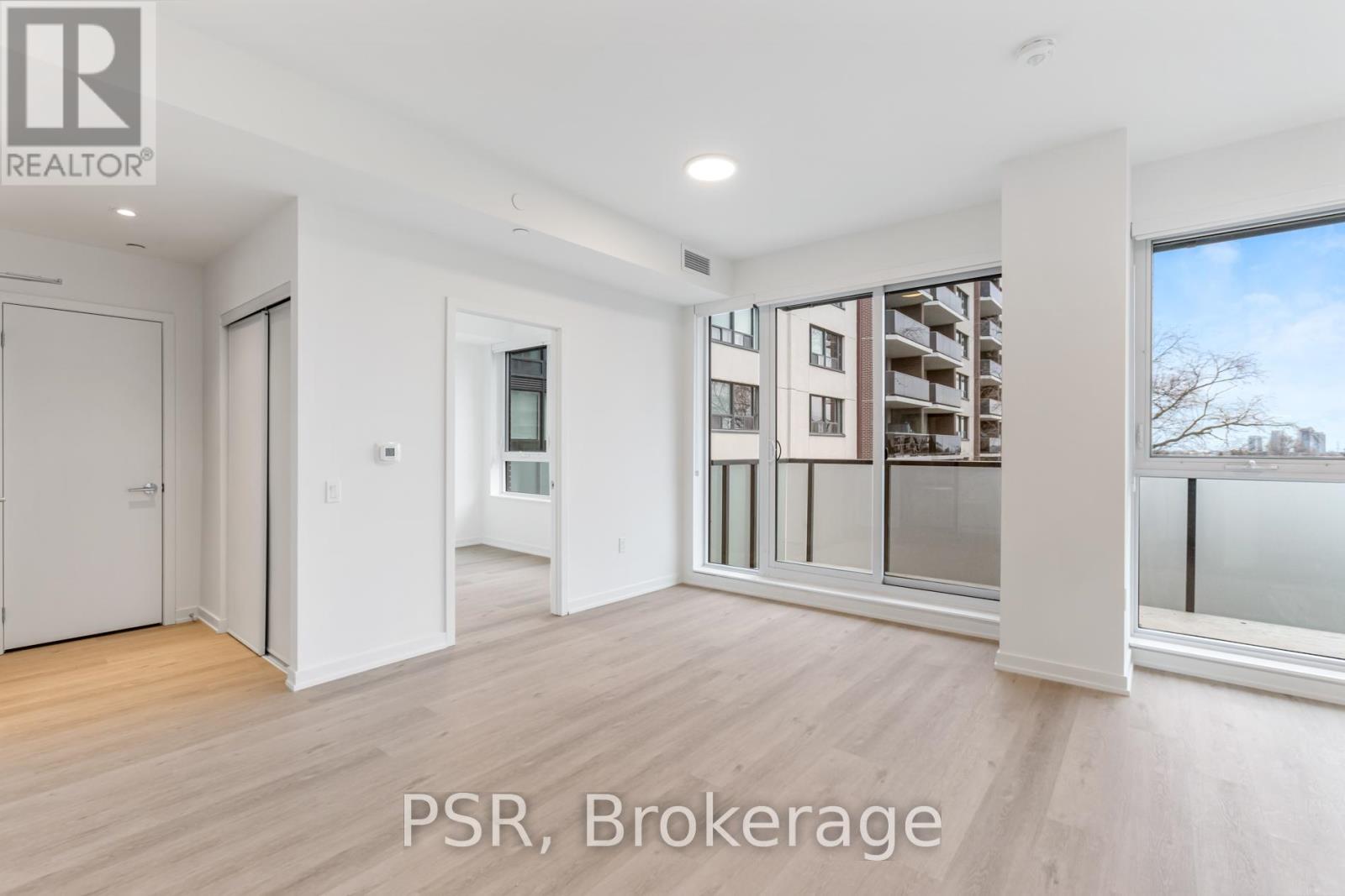 A spacious room with a view of a building across the street.