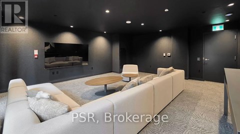 A modern living room with a grey carpet and a white sofa.