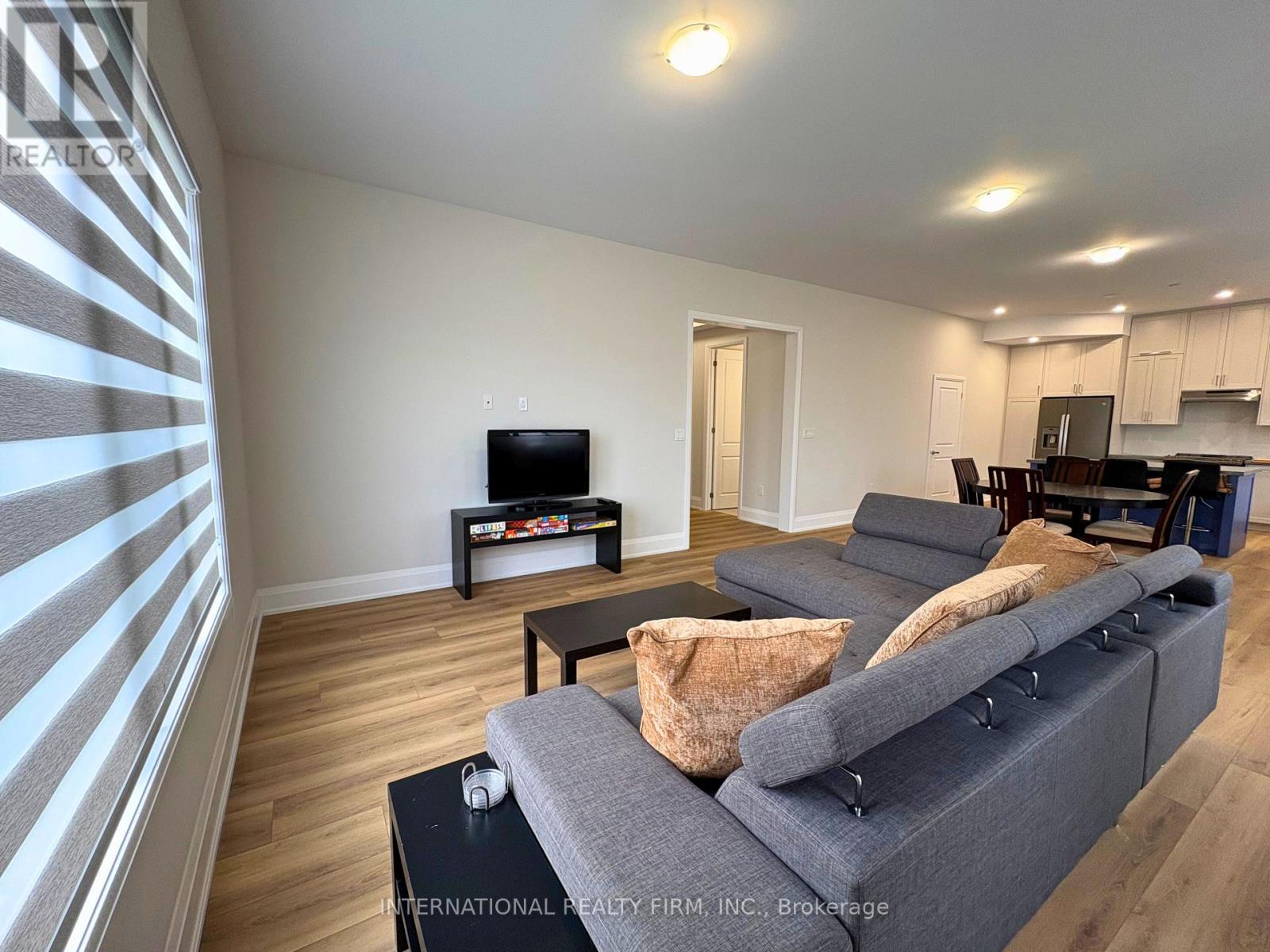 A living room with a grey sofa and a television.