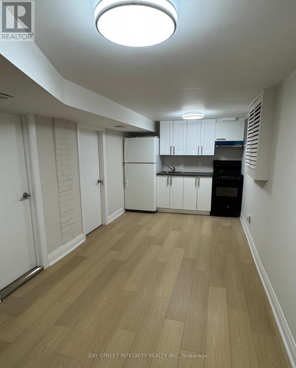 A kitchen with white cabinets and a wooden floor.
