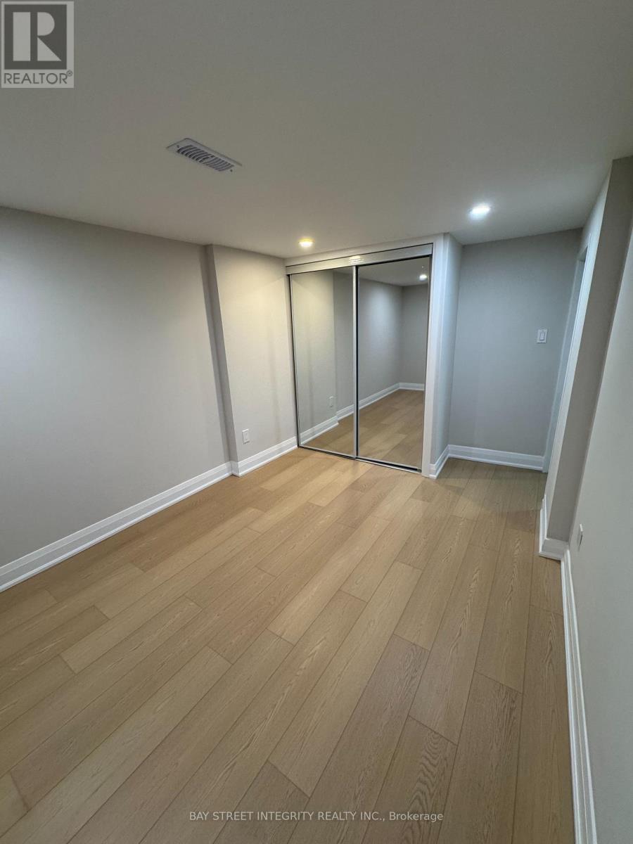 A room with wooden flooring and white walls, with a glass door in the middle.