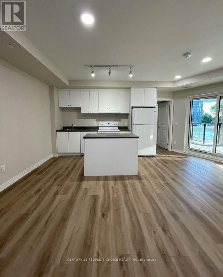 A kitchen with white cabinets and a wooden floor.