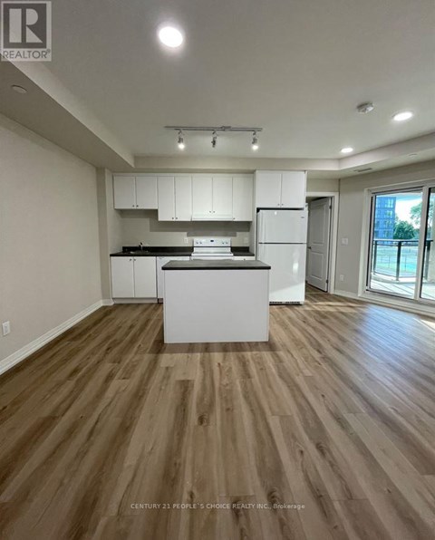 A kitchen with white cabinets and a wooden floor.