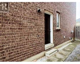 A brick building with a black door and a small window above it.