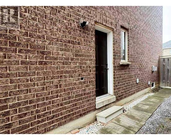 A brick building with a black door and a small window above it.