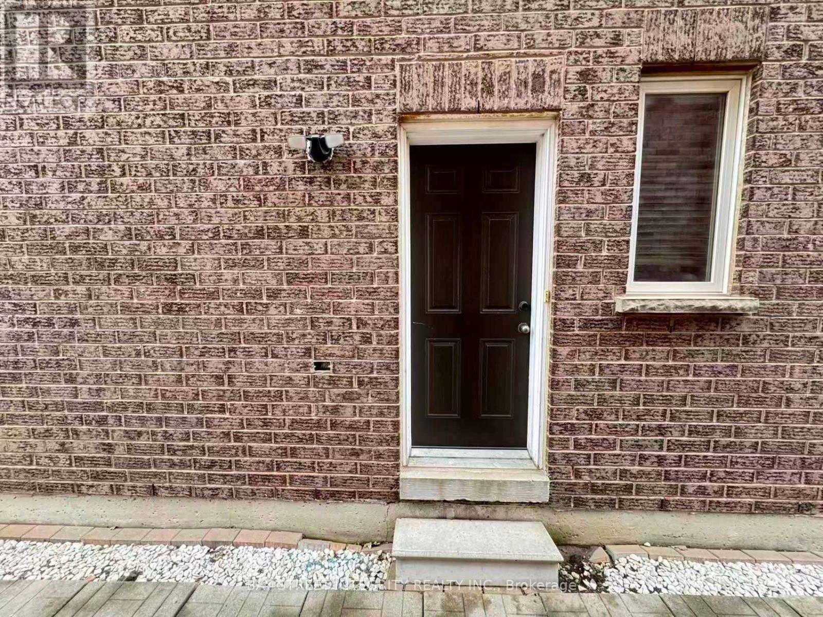 A brick wall with a door and a window.